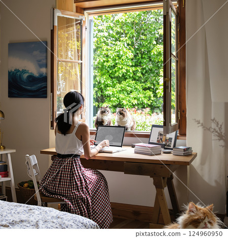 Girl at the window with a computer. 124960950