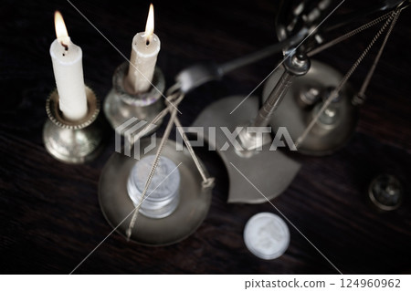 Candle and retro weighing scale with silver dollar coin Candle and retro weighing scale with silver dollar coin 124960962