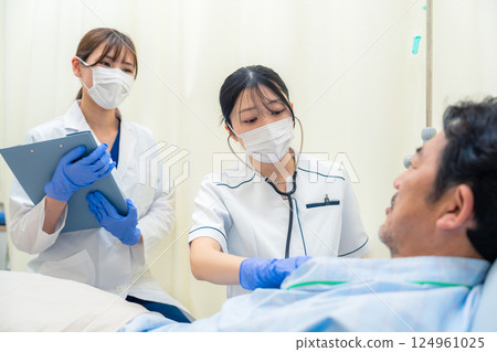 A female nurse checking the vital signs of an inpatient in a hospital ward A female nurse checking the vital signs of an inpatient in a hospital ward 124961025