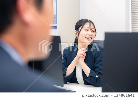 一位活潑的年輕女子在辦公室的辦公桌前工作 124961641
