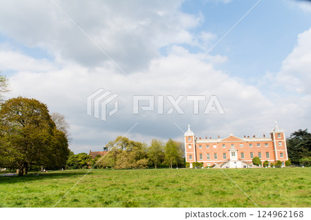 A historic red brick building built in a spacious park under a blue sky in Osterley Park, a suburb of London 124962168