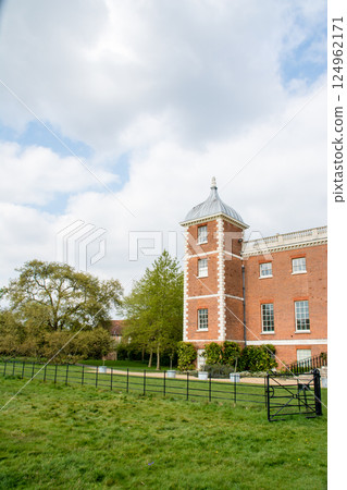 A historic red brick building built in a spacious park under a blue sky in Osterley Park, a suburb of London 124962171