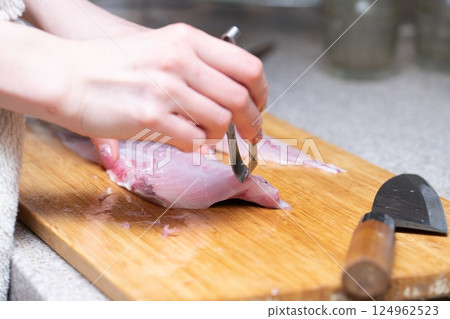 Woman's hands removing fish bones 124962523