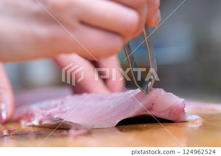 Woman's hands removing fish bones 124962524