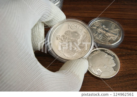 An Australian silver coin in the hand of a numismatist. Pure silver coin Koala An Australian silver coin in the hand of a numismatist. Pure silver coin Koala 124962561