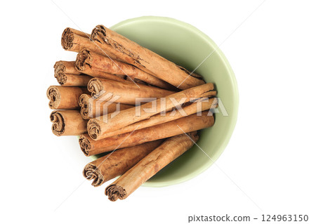 Cinnamon sticks in ceramic bowl isolated on white background with full depth of field. Top view. Flat lay. 124963150