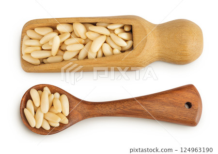 Shelled European pine nuts in wooden scoop and spoon isolated on white background. Top view. Flat lay 124963190