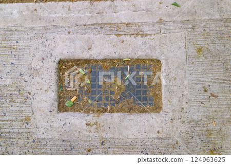 A solid concrete surface featuring a squareshaped hole located in the center 124963625