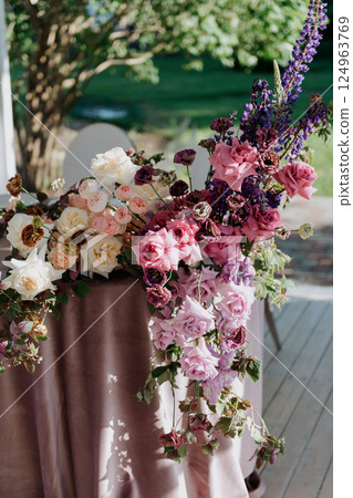 A beautifully arranged table featuring pink and purple flowers on it 124963769