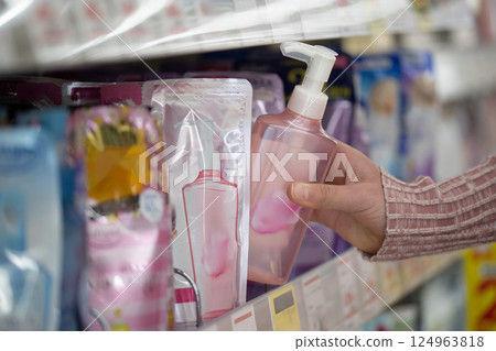 Woman's hand choosing detergent 124963818