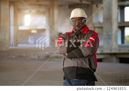 African american worker stands at construction area and looks at camera African american worker stands at construction area and looks at camera 124963855