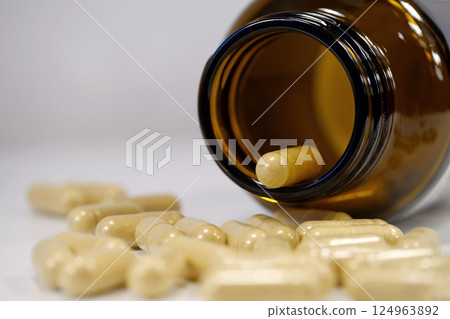 Capsules with vitamins for men and an open jar lies on table 124963892
