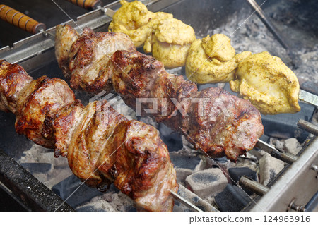 Big fat shish kebab broils in barbecue. Fatty, unhealthy, partially burnt meat Big fat shish kebab broils in barbecue. Fatty, unhealthy, partially burnt meat 124963916