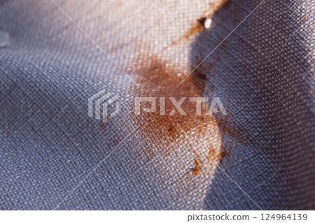 Stained Fabric CloseUp Detailed View of Patterned Material Featuring an Orange Mark 124964139