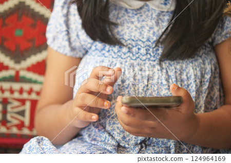 Child girl watching cartoon on smart phone  124964169
