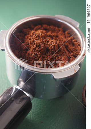 Freshly ground coffee in a portafilter ready for brewing espresso Freshly ground coffee in a portafilter ready for brewing espresso 124964207