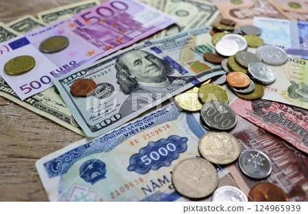 Banknotes of different countries and colors on a wooden background 124965939
