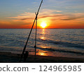 Fishing from the sandy beach, spinning rods and fishing rods stand on the shore 124965985