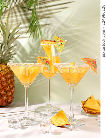 Various alcoholic cocktails with slices of mango, pineapple and ice in glasses with rims and umbrellas. Concept of a tropical party and relaxation. Advertising business card for a bar menu. Various alcoholic cocktails with slices of mango, pineapple and ice in glasses with rims and umbrellas. Concept of a tropical party and relaxation. Advertising business card for a bar menu. 124966120