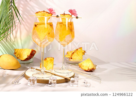 Royal lemonade cocktail with mango slices, pineapple, rum, tequila, vodka and ice cubes. Summer tropical party concept, advertising and menu for bar and restaurant, Cold frozen punch. 124966122