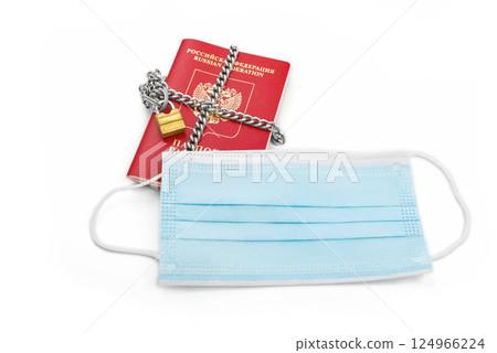 Passport with a medical mask on a white background. Passport with a medical mask on a white background. 124966224