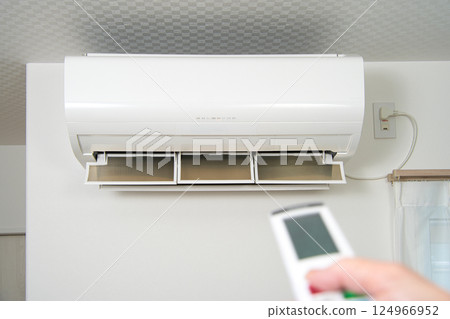 操作空調遙控器的女性手 操作空調遙控器的女性手 124966952