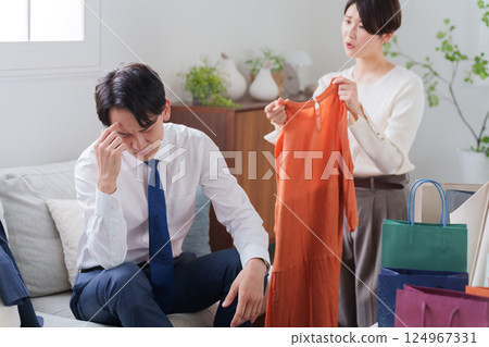 A wasteful wife buying clothes and an angry husband (marital quarrel) A wasteful wife buying clothes and an angry husband (marital quarrel) 124967331