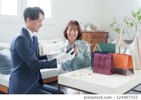 A mobile used buyer assessing the items with a female customer A mobile used buyer assessing the items with a female customer 124967332