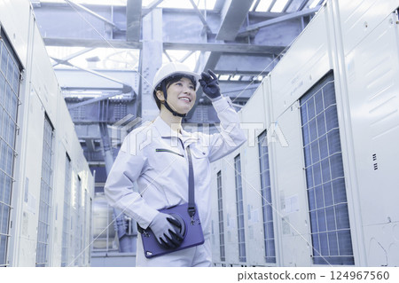 一名年輕女工在建築物屋頂上進行檢查工作。照片由東京電子專門學校、電波學園株式會社提供。 124967560