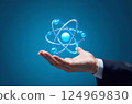 Bussinessman hand holding an atom icon on a blue background, concept of future technology, infinite energy 124969830