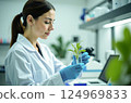 Biotechnology, nature and the female scientist in the lab, research with a plant in a test tube to test gmo's 124969833