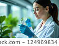 Biotechnology, nature and the female scientist in the lab, research with a plant in a test tube to test gmo's 124969834
