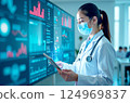 A young female Asian doctor in a white coat studies graphs on an interactive screen, the business of medicine 124969837