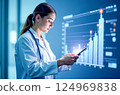A young woman doctor in a white coat learns diagrams on an interactive screen, business in medicine 124969838