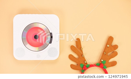 White portable CD player with red headphones on a beige background. 124971945