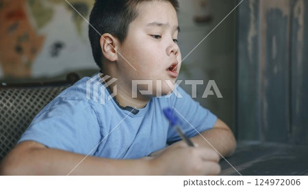asian boy think deeply, homework near wall map and vintage paneling, mouth slightly open in concentration, tutoring, parenting blog, educational service asian boy think deeply, homework near wall map and vintage paneling, mouth slightly open in concentration, tutoring, parenting blog, educational service 124972006