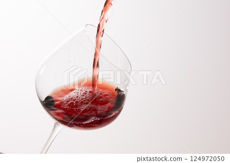 Pour the red wine into the glass Pour the red wine into the glass 124972050