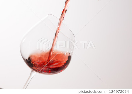 Pour the red wine into the glass 124972054