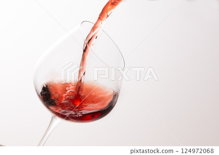Pour the red wine into the glass Pour the red wine into the glass 124972068