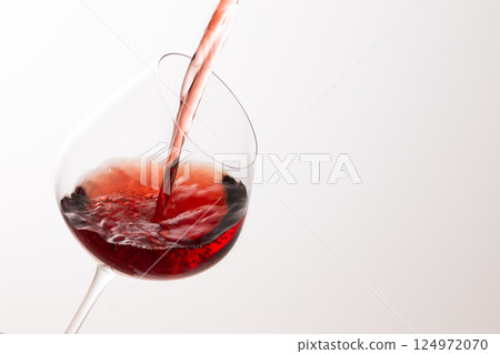Pour the red wine into the glass Pour the red wine into the glass 124972070