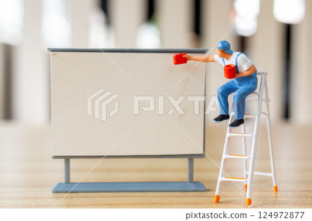 Miniature figurine painting a blank sign or board. Miniature figurine painting a blank sign or board. 124972877