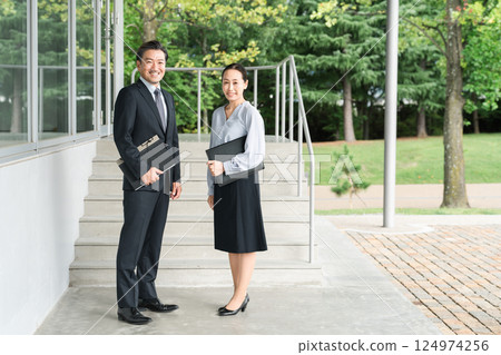 Male and female teachers moving through school corridors (high school and junior high school) 124974256