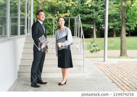 Male and female teachers moving through school corridors (high school and junior high school) 124974258