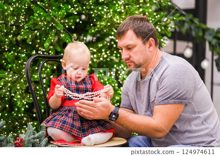 Dad and daughter fooling around near the Christmas tree Dad and daughter fooling around near the Christmas tree 124974611