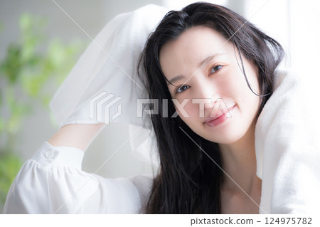 一位女士用毛巾擦乾濕髮 一位女士用毛巾擦乾濕髮 124975782