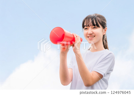 Junior high school, high school, and elementary school girls in gym clothes cheering with megaphones 124976045