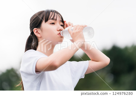 Female junior high school students and high school students in gym clothes hydrating during exercise Female junior high school students and high school students in gym clothes hydrating during exercise 124976280