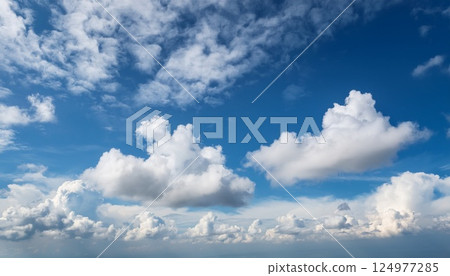 明亮的正午天空點綴著蓬鬆的白雲 明亮的正午天空點綴著蓬鬆的白雲 124977285