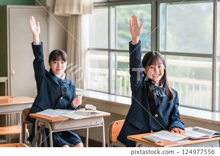 Active elementary school students, junior high school students, high school students, and high school girls (friends) in uniforms raising their hands during class in a school classroom Active elementary school students, junior high school students, high school students, and high school girls (friends) in uniforms raising their hands during class in a school classroom 124977556