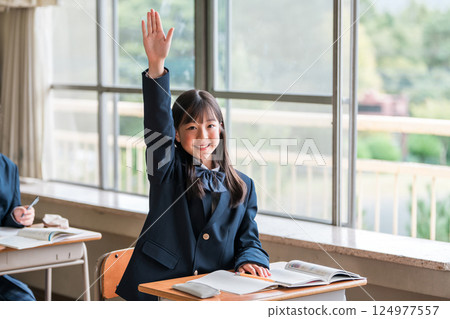 Active elementary school, junior high school, high school and high school girls in uniforms raising their hands during class in a school classroom Active elementary school, junior high school, high school and high school girls in uniforms raising their hands during class in a school classroom 124977557